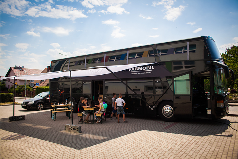 Fabmobil - ein Bus, vor dem ein Pavillion steht